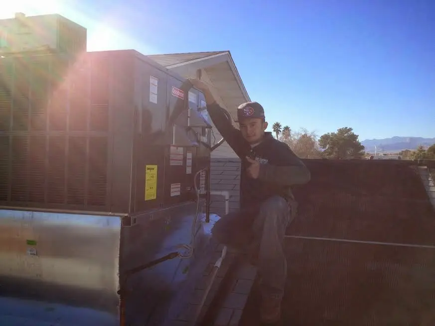 HVAC technician performing AC Tune-Up on a rooftop unit in East Norriton
